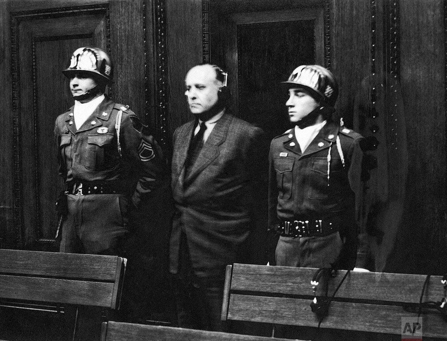 Richard Walther Darre, former SS Senior Group Leader and Reich Minister, accused of war crimes as a leading Nazi 'blood and soil' ideologist during WWII, escorted by U.S. military police at Nuremberg.
