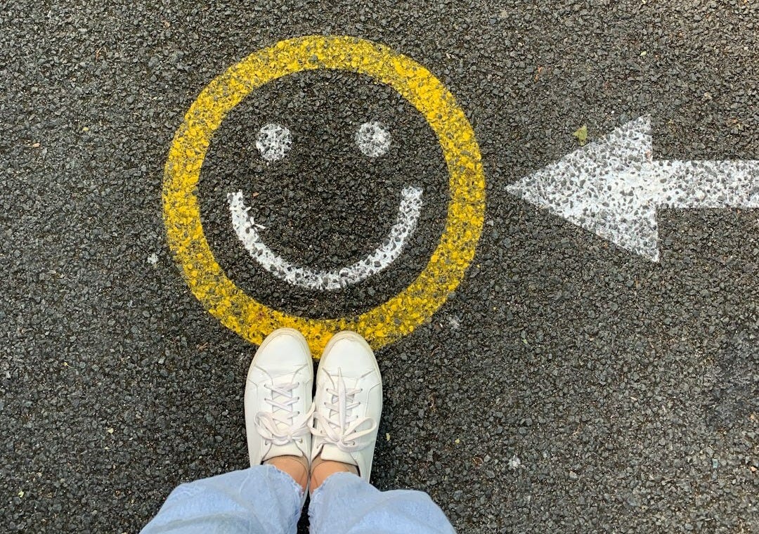person in white shoes standing on gray concrete road