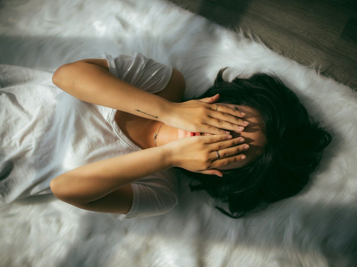 a woman holds her hands over her face a woman holds her hands over her face