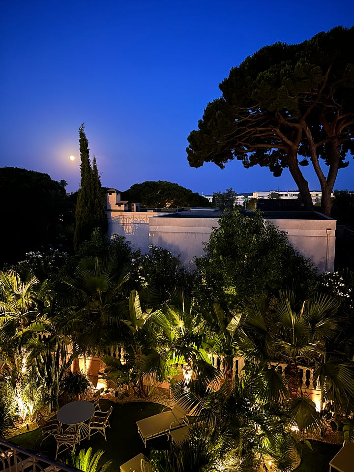 Two photos of France at night: one after the moon has risen over a garden, and one as the sun sets into the Mediterranean.