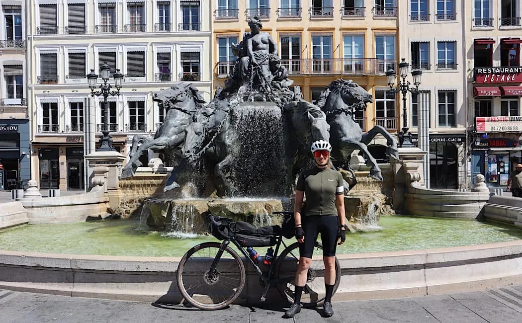 Jeune femme avec son velo devant la fontaine de la place des terreaux a Lyon Jeune femme avec son velo devant la fontaine de la place des terreaux a Lyon