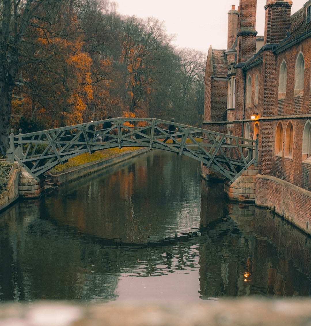 a bridge over a river next to a brick building