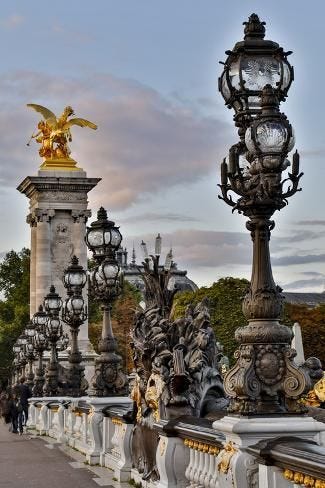 This may contain: the bridge is lined with ornate statues and street lamps, along with a statue of an eagle on top