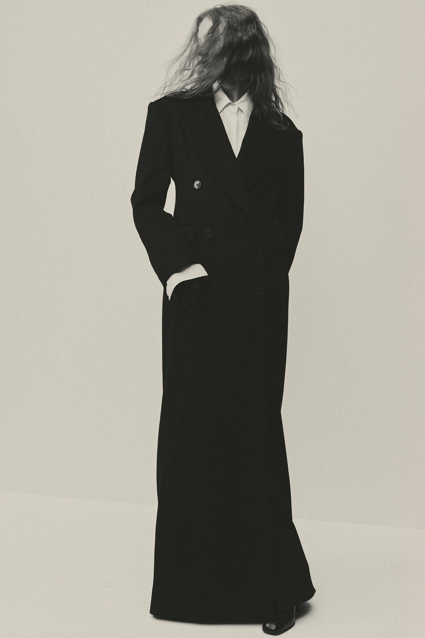 Image may contain Clothing Coat Adult Person Overcoat Long Sleeve Sleeve Formal Wear and Suit