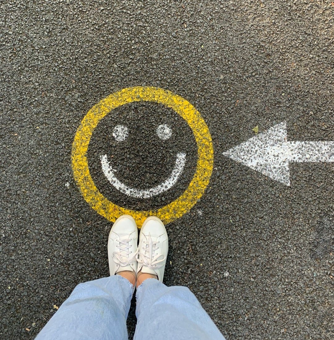person in white shoes standing on gray concrete road