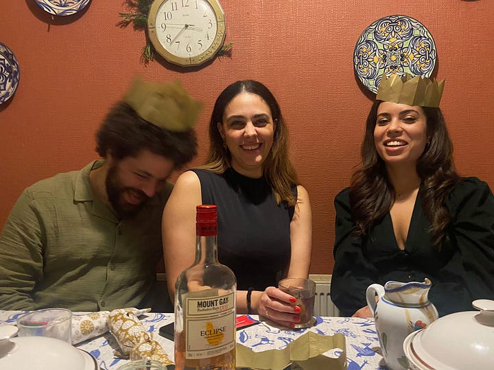 A male and two females sit behind a table with Christmas crackers on