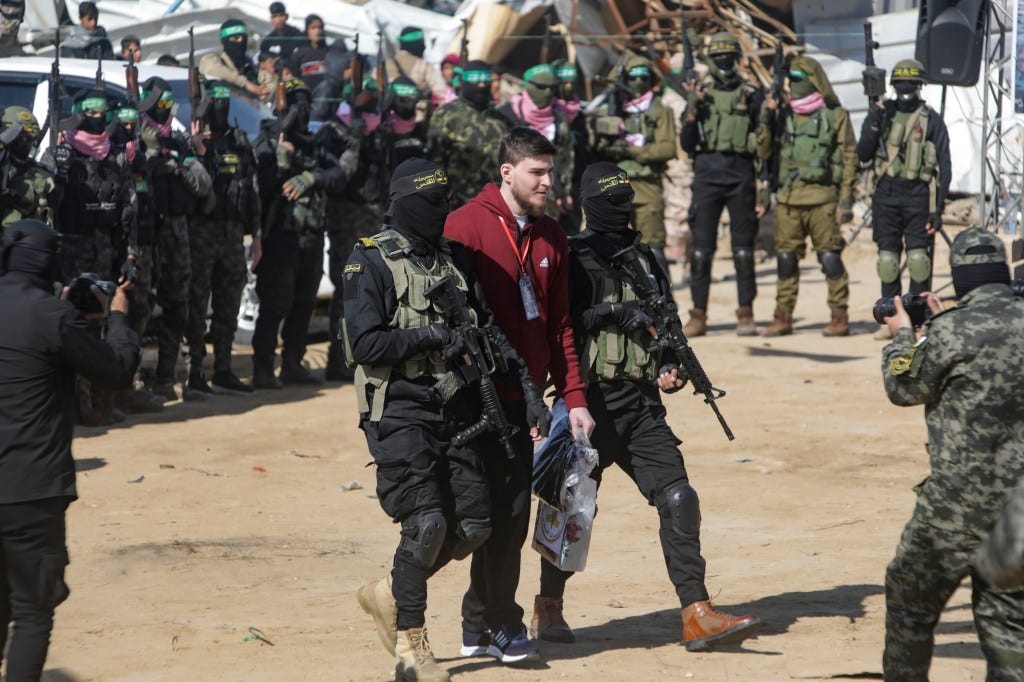 Troufanov is escorted by terrorists as he is handed off to the Red Cross in the Gaza city of Khan Younis. Troufanov is escorted by terrorists as he is handed off to the Red Cross in the Gaza city of Khan Younis.