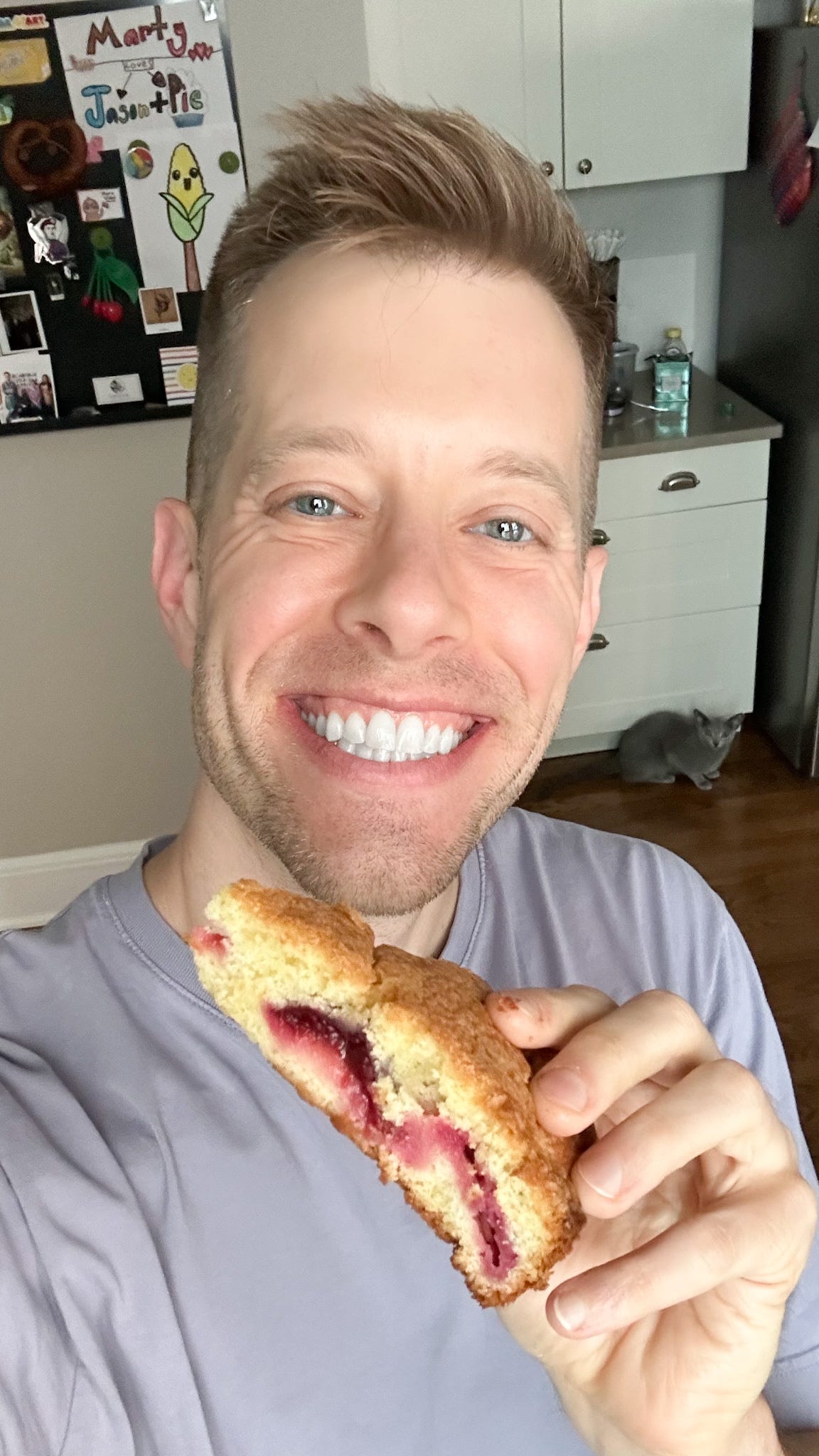 Martin grinning while holding a slice of plum torte. 