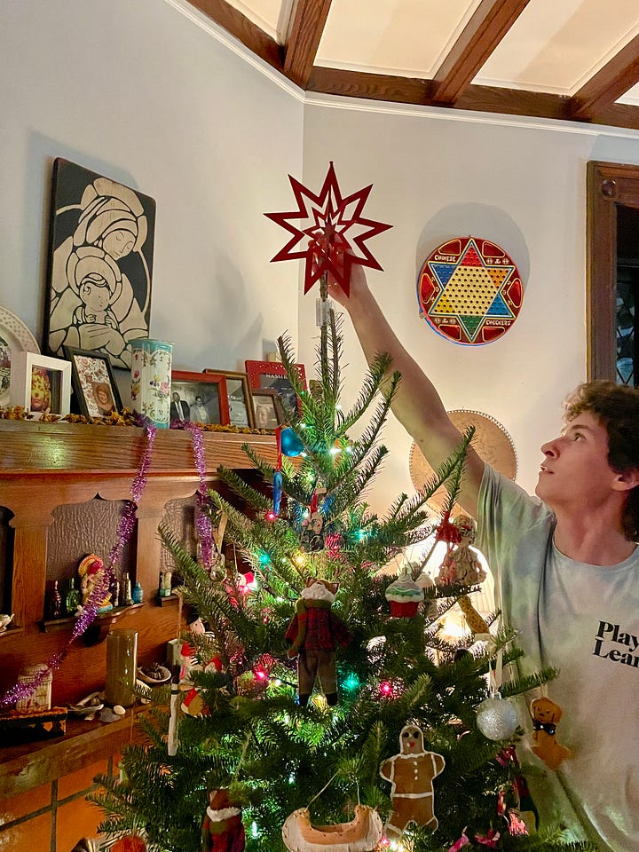 four photographs of a christmas tree, one close up, one with a young man placing the star on the top of the tree, and one of a grey cat playing with a string of lights