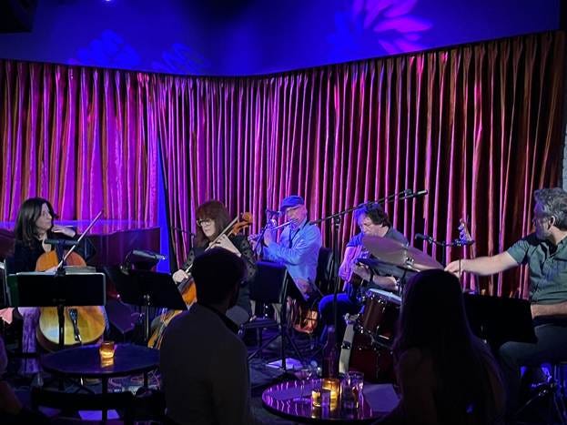 A group of people playing instruments

AI-generated content may be incorrect.