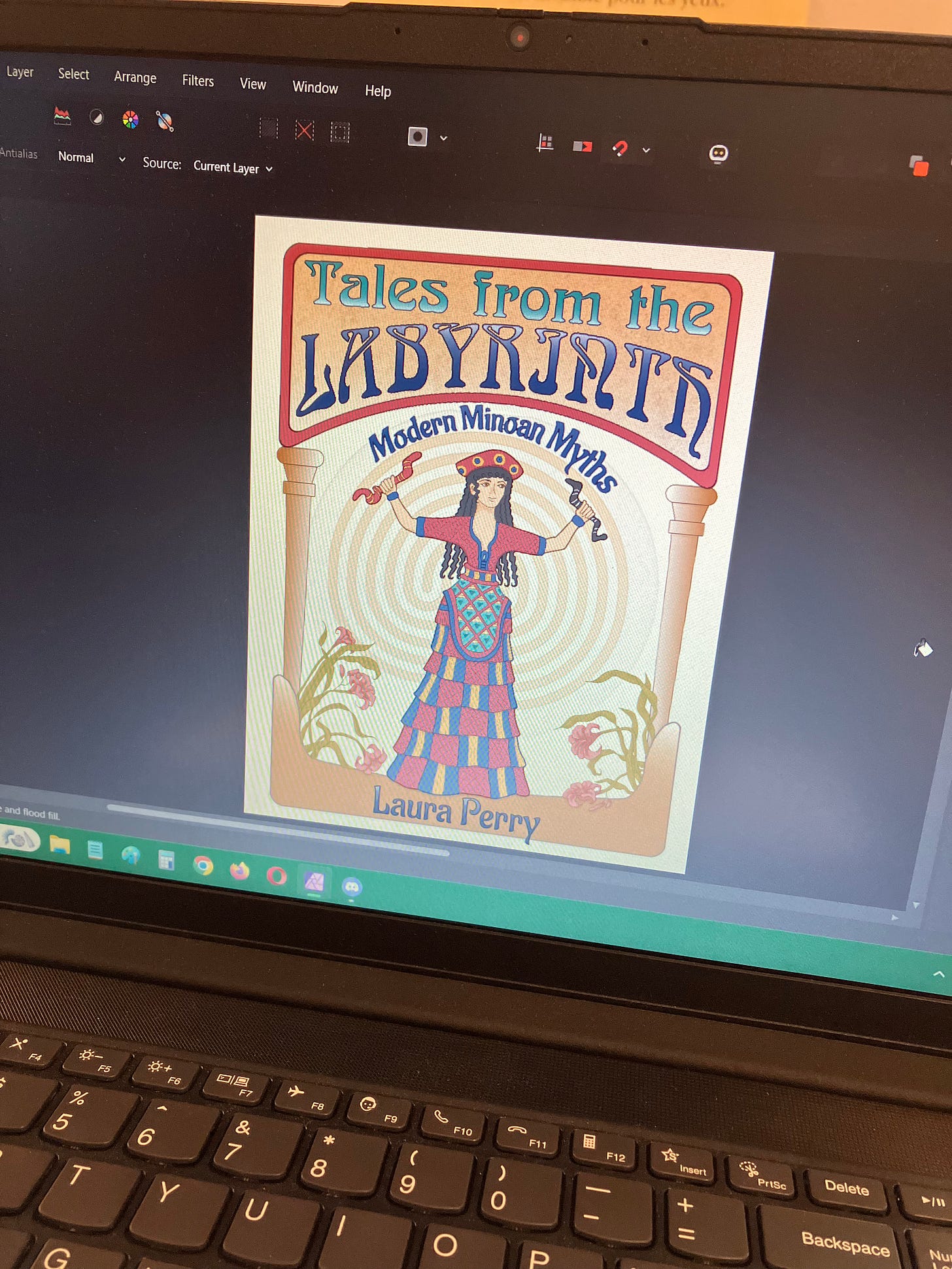 A laptop screen showing art with the title "Tales from the Labyrinth" at the top, a Snake Goddess with a labyrinth behind her, flanked by a pair of pillars and pink lilies, with a pair of Minoan sacred horns at the bottom.
