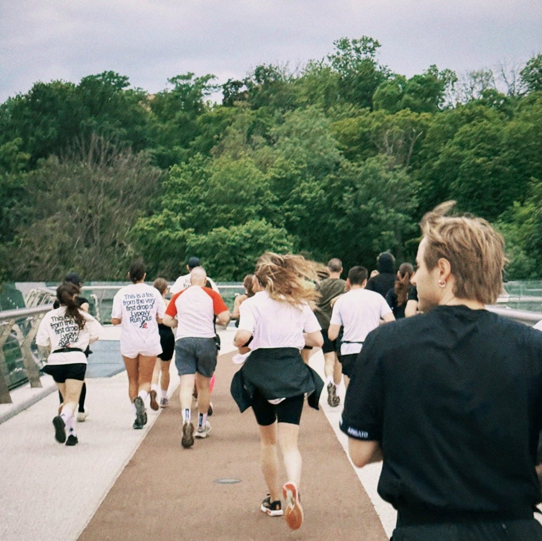 Runners are racing on a path with green trees. Runners are racing on a path with green trees.