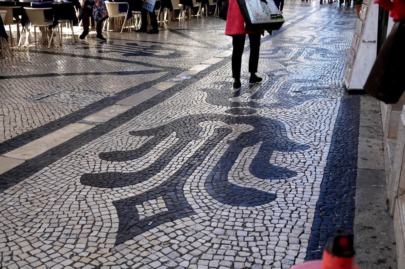 A group of people walking down a street holding an umbrella

Description automatically generated