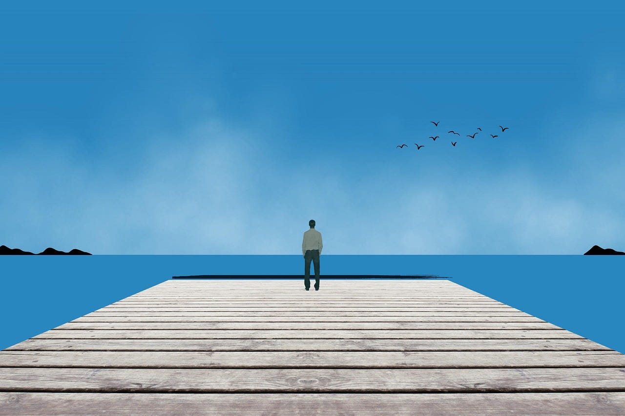 blue sky over a man standing in the distance on a wide dock on the sea (write by hand)