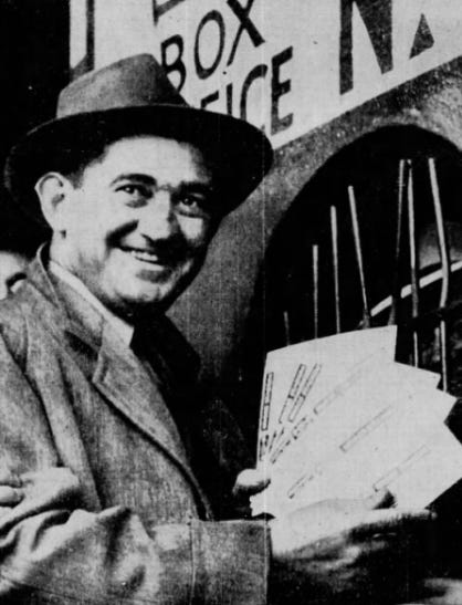 Wearing civilian clothes, Mickey Cochrane shows off World Series tickets.