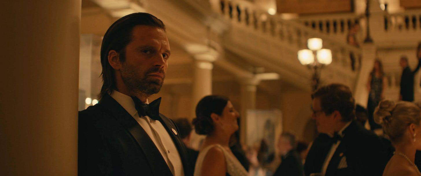 Bucky with his hair slicked back. He wears a suit and looks sneaky at a gala