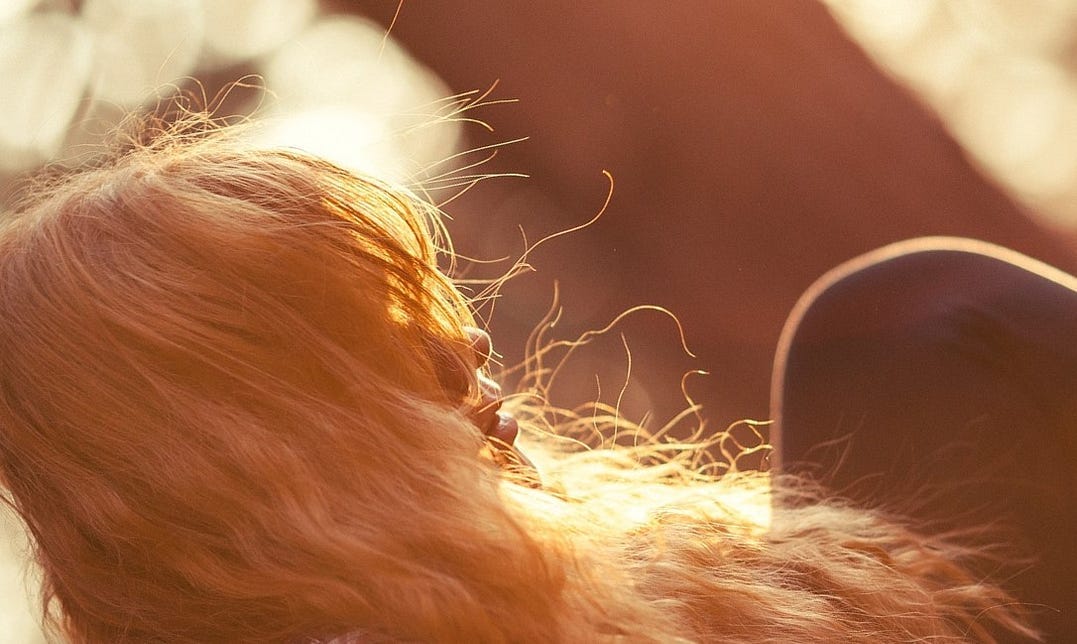 Young woman sitting outside in the fading sunlight