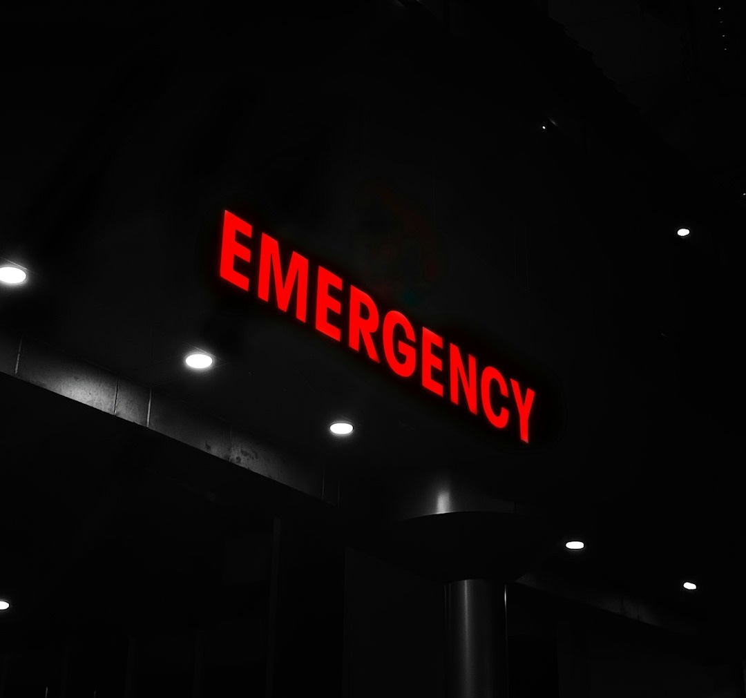 Red emergency sign illuminates a dark building entrance.