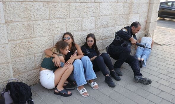 Israelis take cover as sirens sound near the beach in Tel Aviv on October 24. Israelis take cover as sirens sound near the beach in Tel Aviv on October 24.