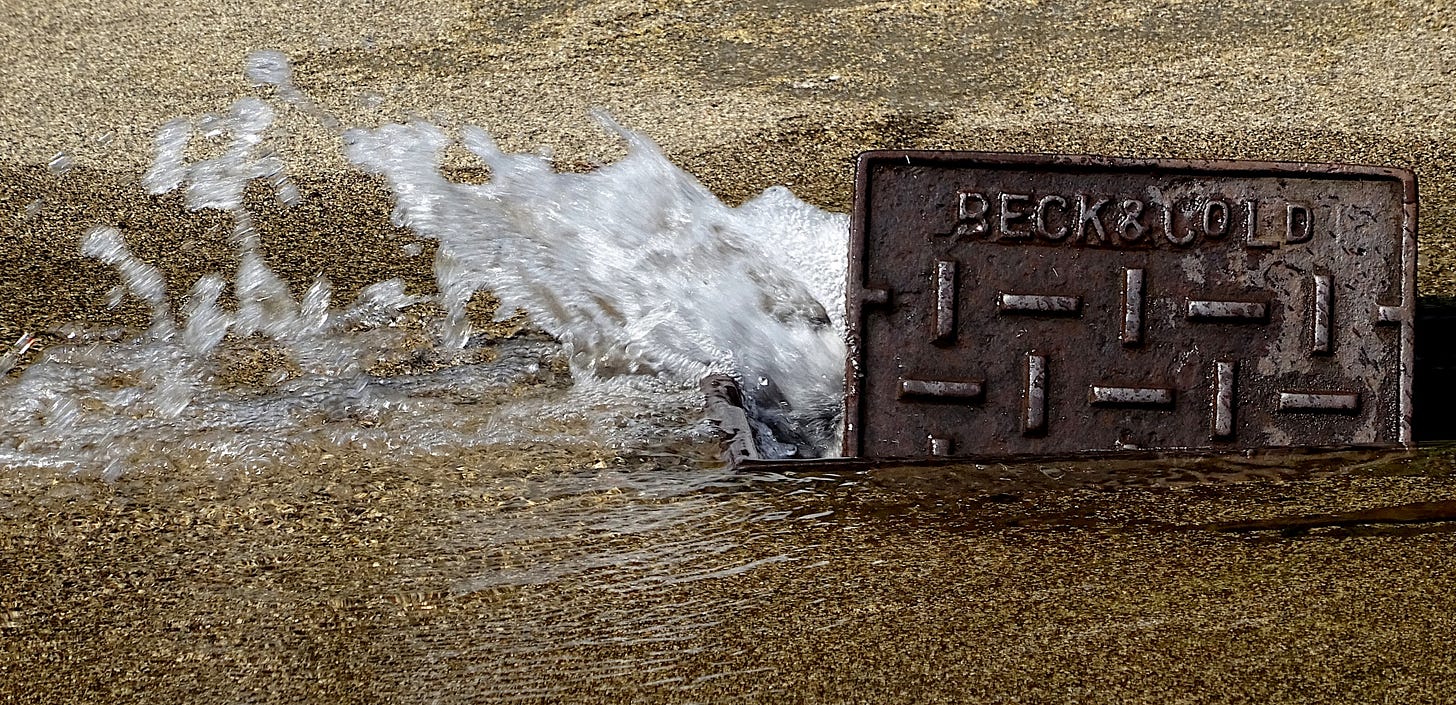 Water escaping from a burst water main. Water escaping from a burst water main.
