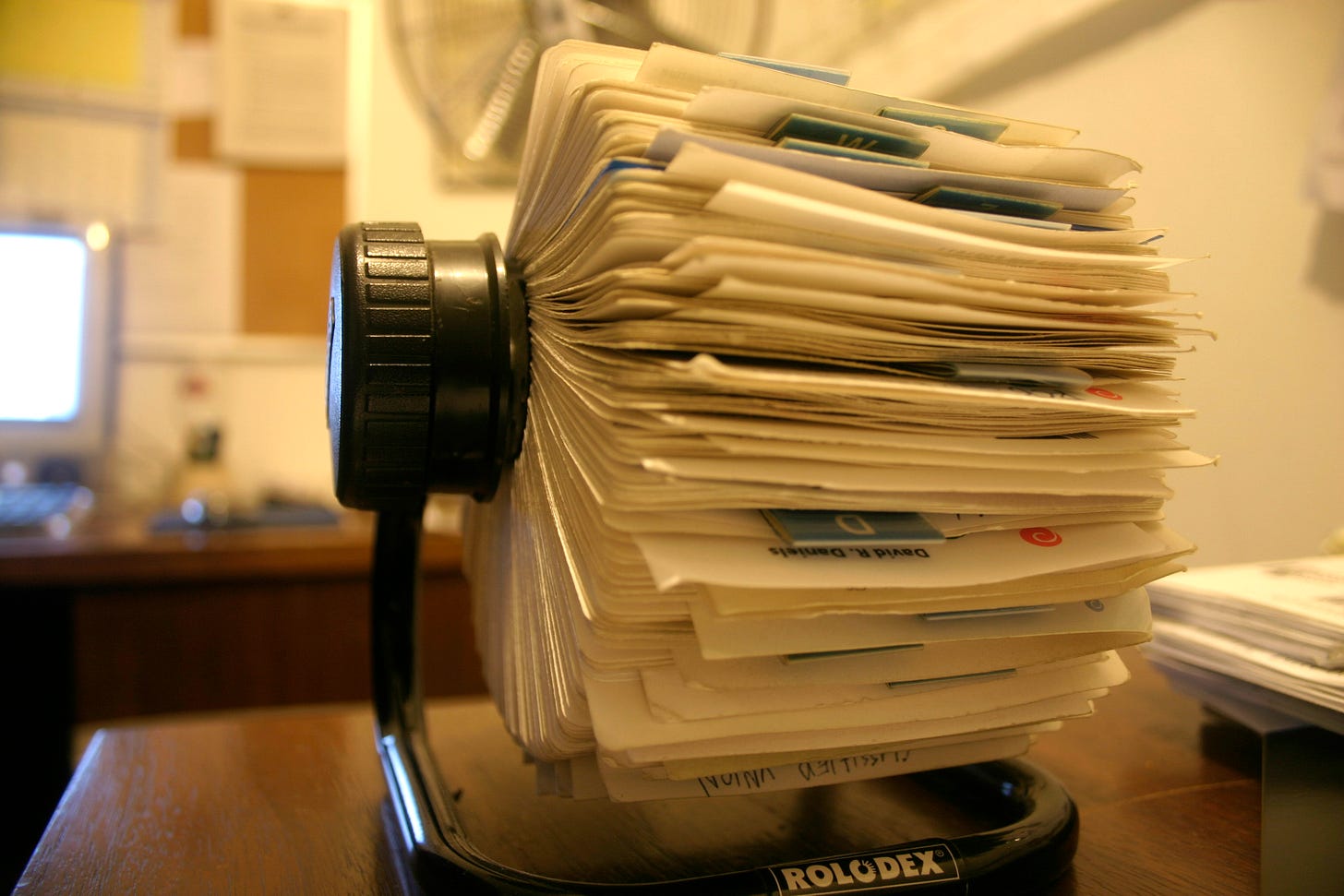 Image of rolodex sitting on a wooden desk in an office