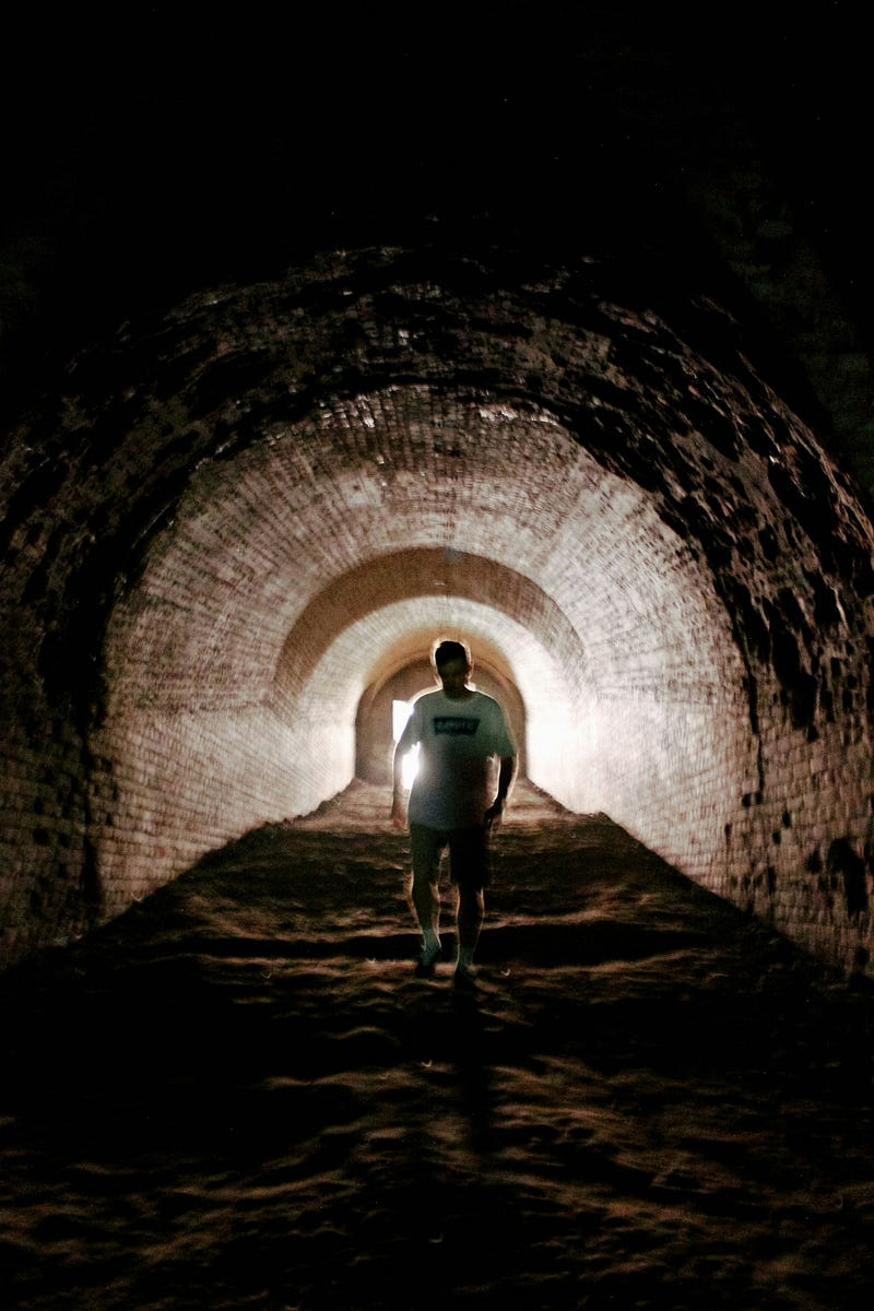 person walking in underground tunnel