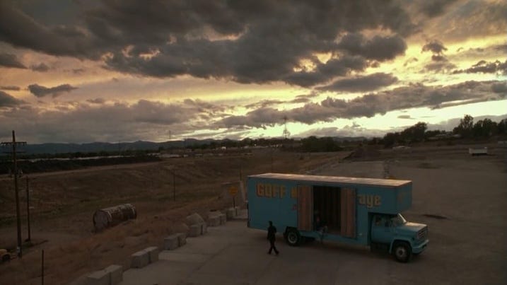 Truck at Dusk: A wide shot of a blue moving truck labeled “Goff Moving & Storage” under dramatic, stormy Colorado skies.