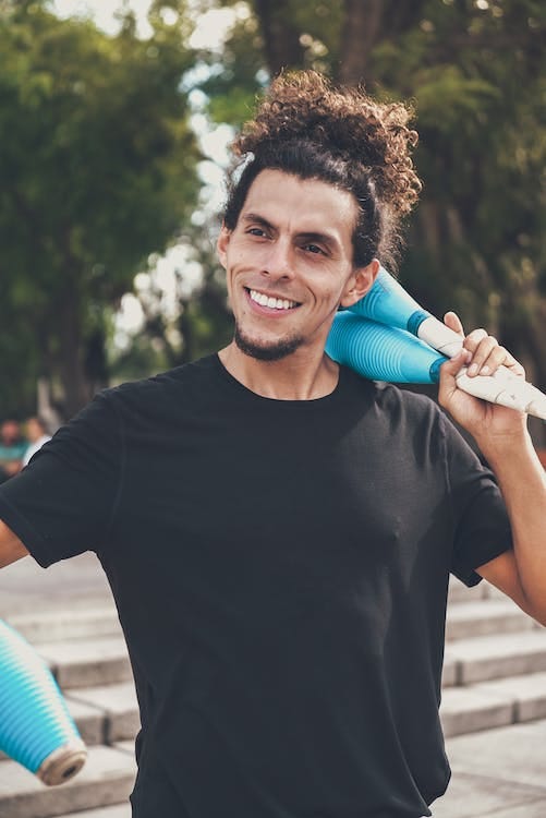 Free 
A Man in a Black Shirt Holding Juggling Clubs Stock Photo