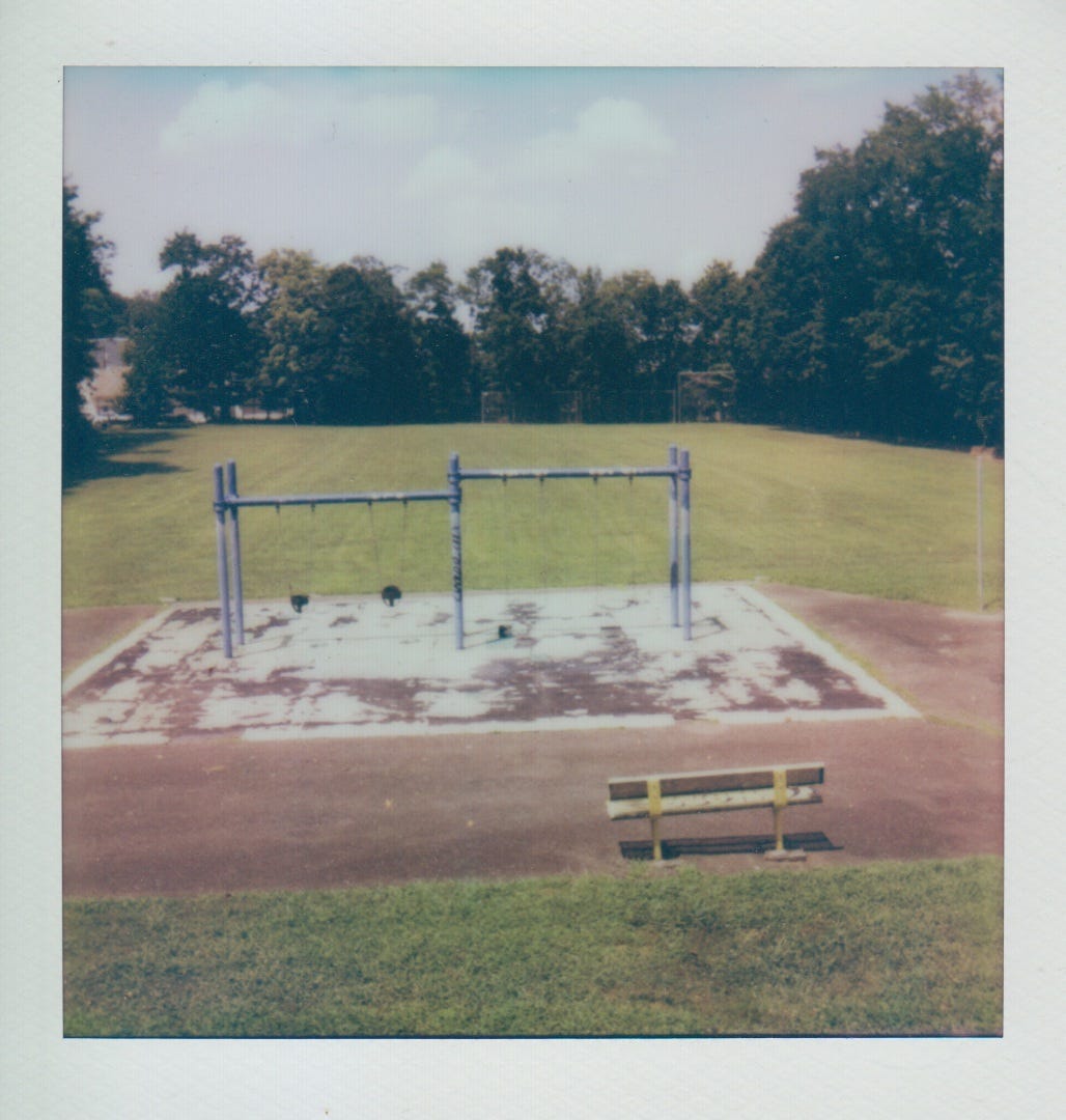Polaroid of the playing field and swing set.