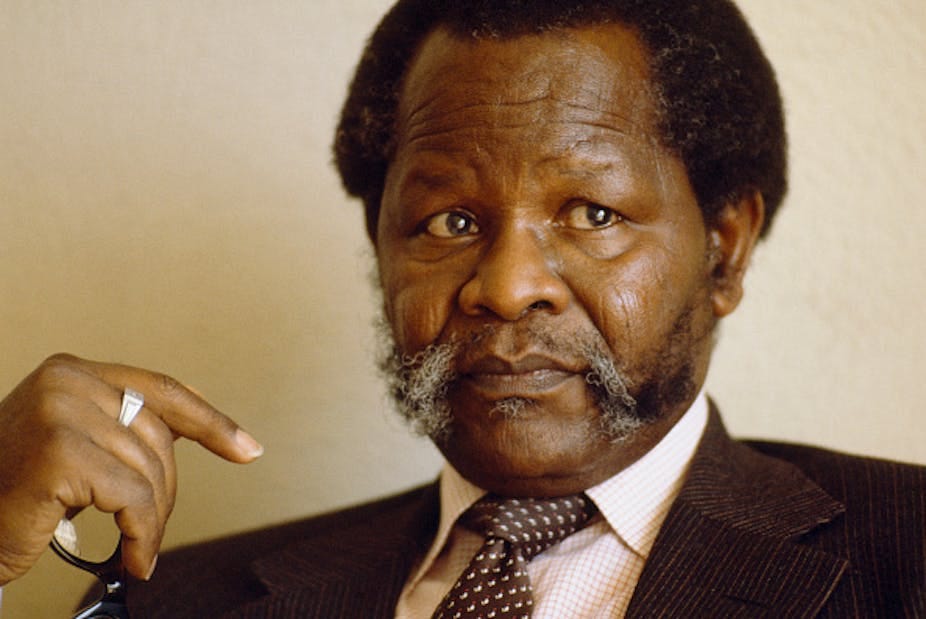 A serious looking man with a ring on his middle finger, wearing shirt, tie and corduroy jacket holds specs in the palm of his hand. A serious looking man with a ring on his middle finger, wearing shirt, tie and corduroy jacket holds specs in the palm of his hand.