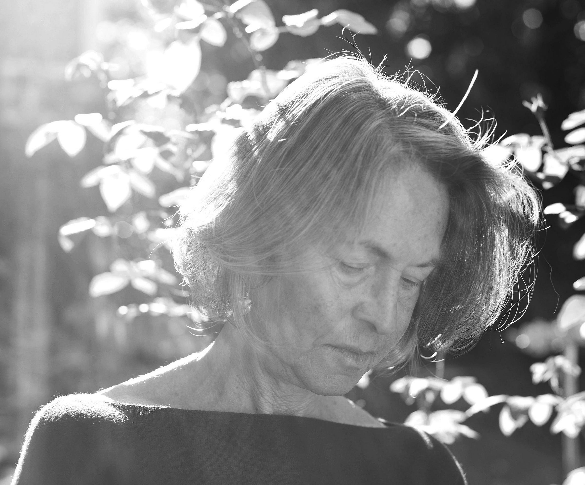 Black and white photograph of writer Louise Glück outside looking down