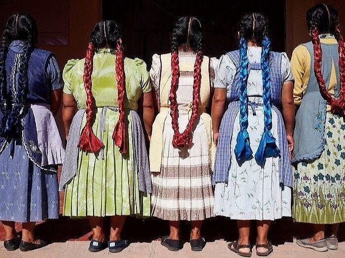 This may contain: four women in colorful dresses are standing next to each other and facing away from the camera