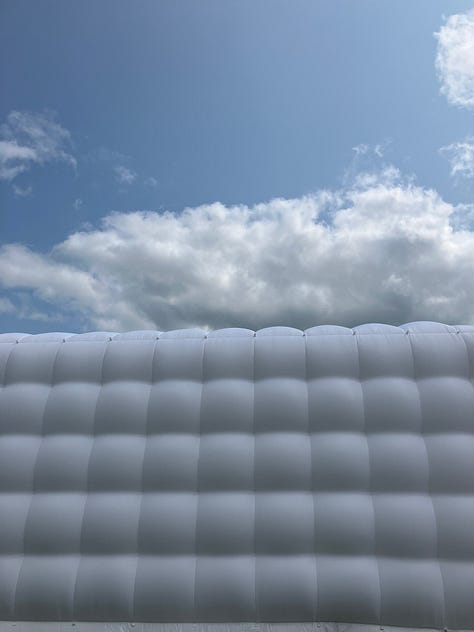 Smooth and shiny electric blue; close-up of a post-race car tyre; a big puffy pop-up building