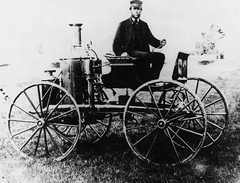 Sylvester sitting on his steam carriage, which later involved into a steam-powered bike