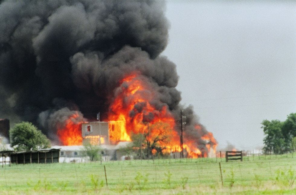 flames erupting from a compound, with smoke billowing into the air