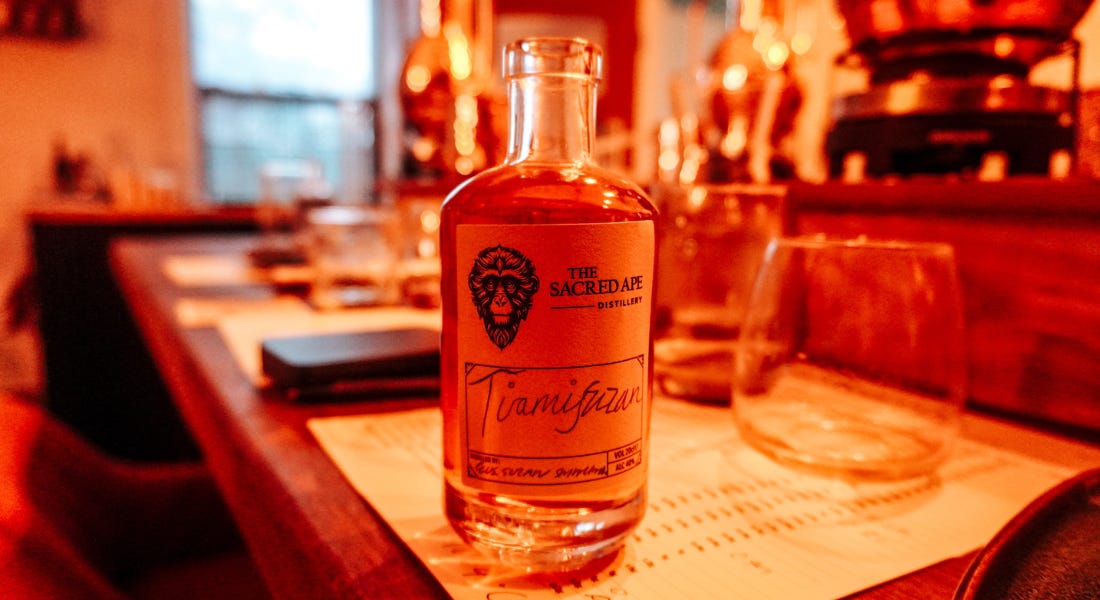 A bottle of rum with a label that says tiramisuzan on a wooden table A bottle of rum with a label that says tiramisuzan on a wooden table