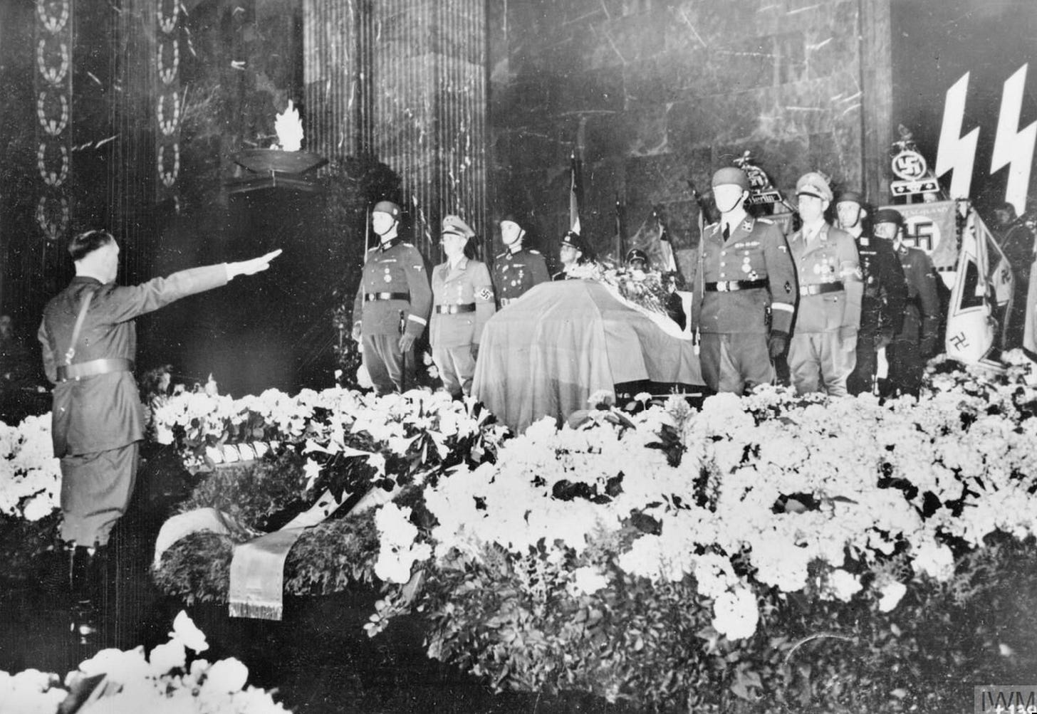 Adolf Hitler salutes the body of Reich Security director Reinhard Heydrich at his 1942 funeral, following Heydrich's assassination by Czechoslovak agents. Dubbed 'the man with the iron heart' by Hitler, Heydrich remains one of the Nazi regime's darkest figures.