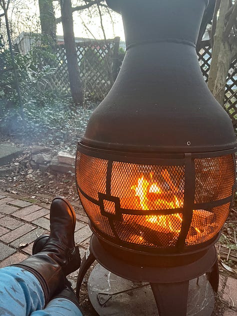 A black figurine of an Egyptian cat. A road lined with blossoming cherry trees. A necklace of aqua colored stones that are cracked and broken. An empty seat and rainy window at a cafe, with coffee on the table. An ikebana arrangement of tall daffodils. A campfire burning inside a potbellied chiminea. A collection of art supplies and a plaster angel. A watercolor sketch of cartoon spiders. A whiteboard at my job bearing the question, What's Your Favorite Thing About Baltimore In The Summer? With many many answers.
