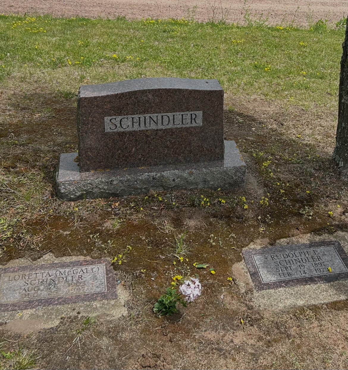 A photo of the cemetery plot of Faux Jean's grandparents. The name "Schindler" is on the large stone.