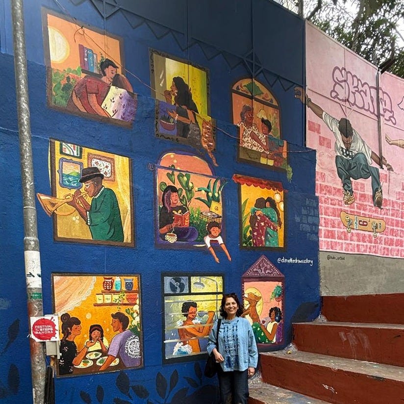 Anu stands beside a mural portraying the people of Mumbai enjoying their lives inside their homes Anu stands beside a mural portraying the people of Mumbai enjoying their lives inside their homes