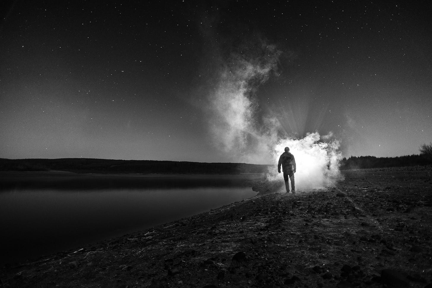 Image of a figure at night, confronting a bright light.