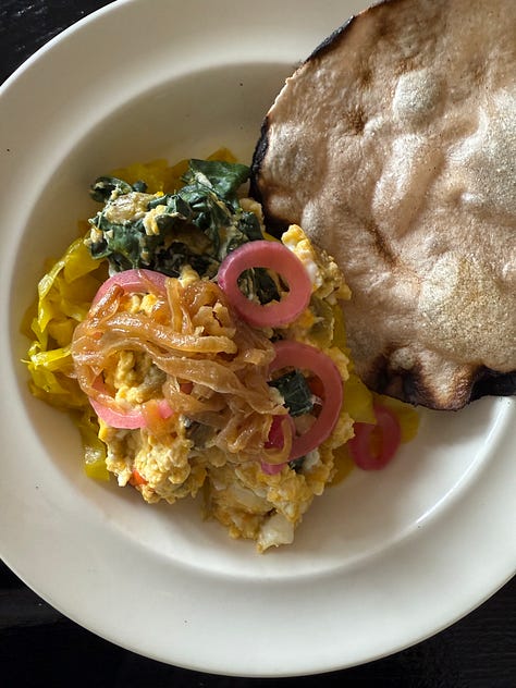A combination of roast vegetables, tinned fish, greens, eggs, tortillas and sauce