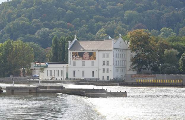 A white building with a poster on the side of it

AI-generated content may be incorrect.