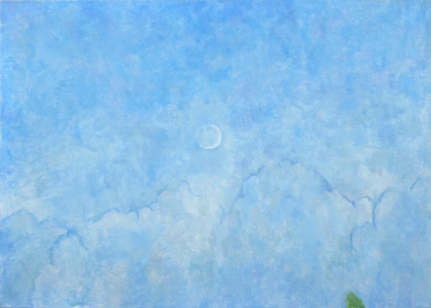 A brilliant blue sky with light atmospheric clouds and a day moon. In the lower right corner is the tip of a green treetop.