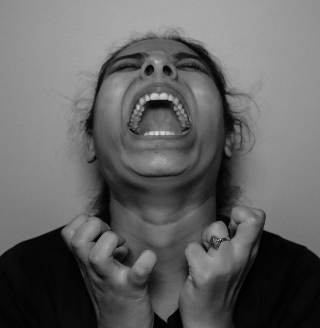 a woman with her mouth open and hands in front of her face