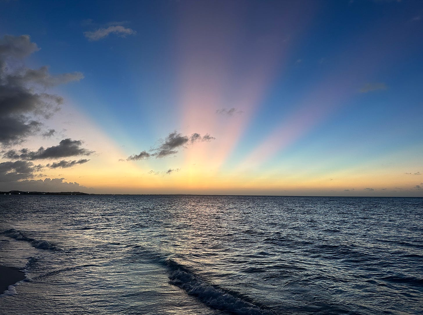 Beach sunset with the sun's rays radiating over the horizon. Beach sunset with the sun's rays radiating over the horizon.
