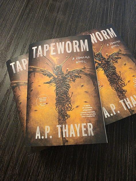 Paperback ARC stack of books, titled Tapeworm, by A.P. Thayer, a horror novel