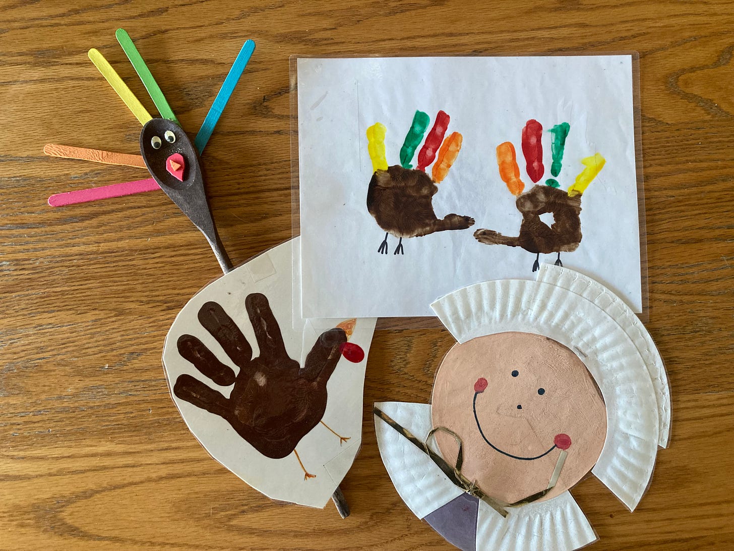 Thanksgiving-themed crafts including a turkey made from a woodern spoon and popsivle sticks, handprint turkeys, and a pilgrim made from a paper plate Thanksgiving-themed crafts including a turkey made from a woodern spoon and popsivle sticks, handprint turkeys, and a pilgrim made from a paper plate