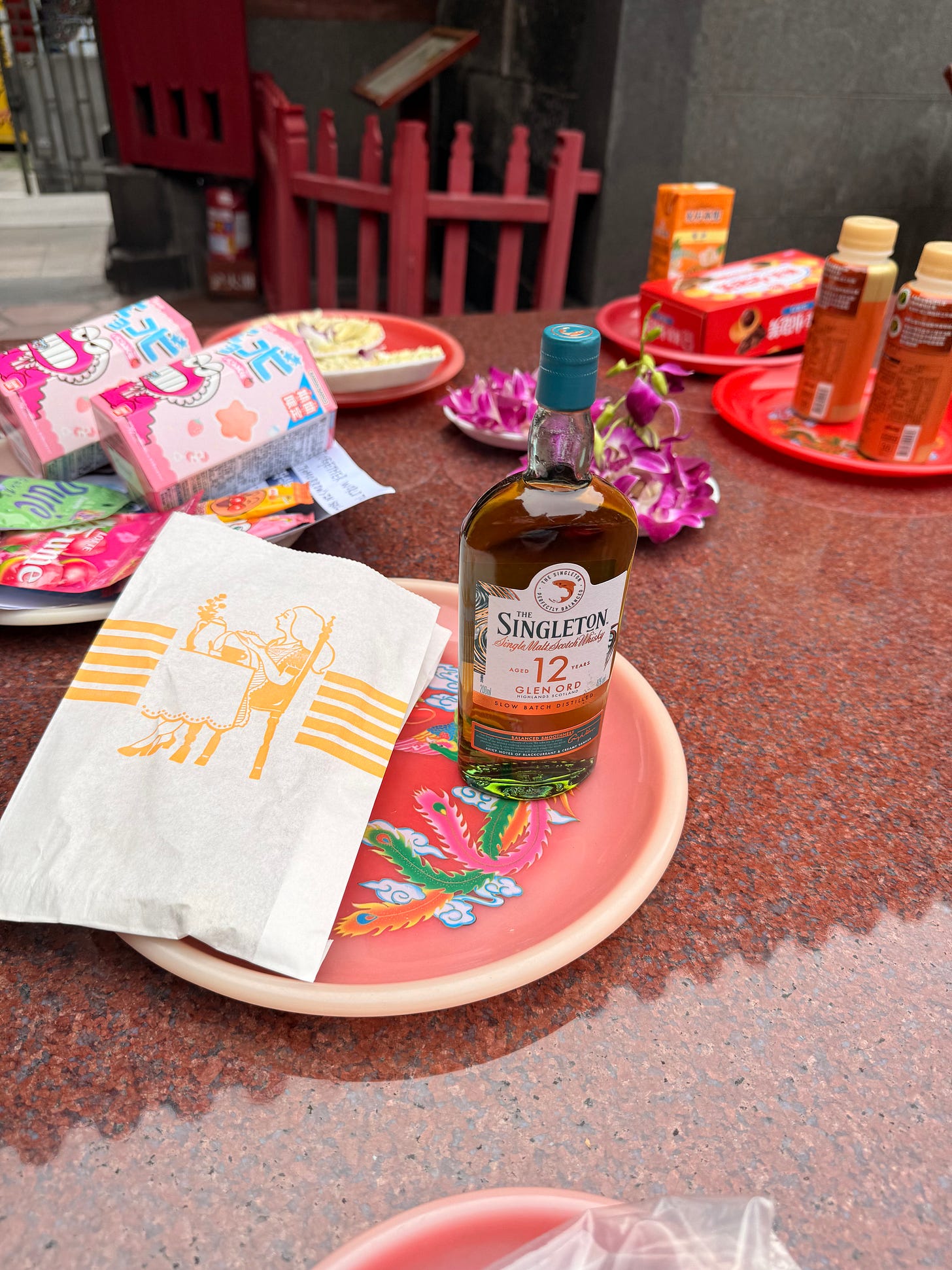 A bottle of whisky among the offerings at Longshan Temple.