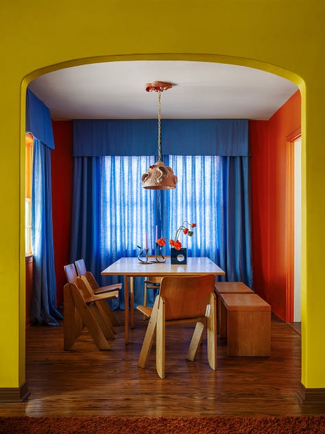 A bathroom with brown tile and yellow details. A green, blue, and purple living room, a primary colored dining room.